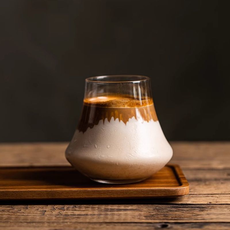 四角い木製トレーに置いたガラスカップのカフェラテ